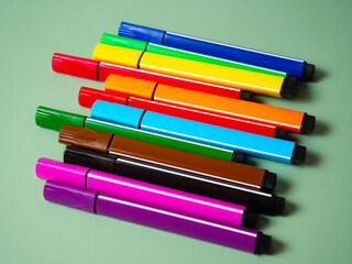 A set of multicolor felt-tip pens, multi-colored felt-tip pens on a green background with space for text