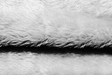 Backdrop close-up photo texture of light colored synthetic fur fold material.