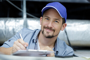 man checking notes in clipboard