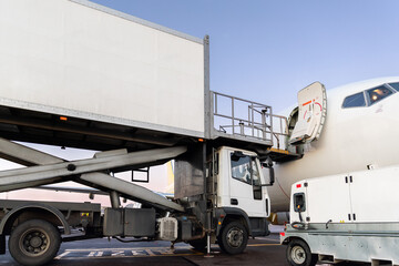 Close-up detail view of highloader cargo catering service truck loading commercial passenger...