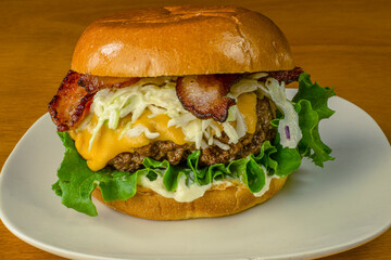 cheese burger top with cole slaw and bacon