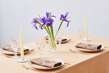 Minimal background image of elegant dinner table decorated with Iris flowers for Spring, copy space