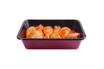 Marinated chicken dramstick in tray for supermarket on white isolated background. Tray for baking.Convenience food,precooked.