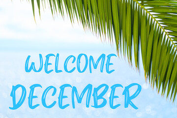 Fototapeta na wymiar Welcome December text on the background with palm leaf and blue sea. Template of a greeting card, postcard or advertisement of a tour agency. 