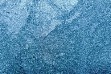 Photo of blue toned frozen concrete tile surface covered in ice texture.