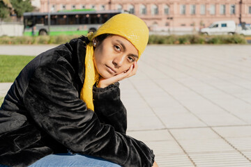 Young Latina worried about cancer, with a scarf covering her head