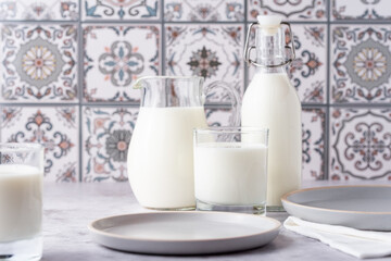 Milk in a glass, decanter and bottle on a light background