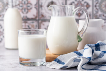 Milk in a glass, decanter and bottle on a light background
