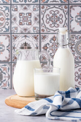 Milk in a glass, decanter and bottle on a light background
