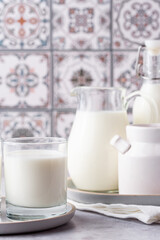 Milk in a glass, decanter and bottle on a light background