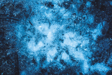 Photo of blue toned frozen ground covered in ice texture.