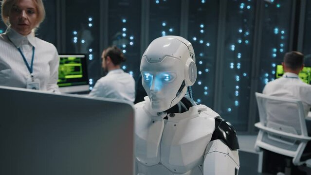 Futuristic AI cyborg using desktop computer typing keyboard programming server data operating at dara center. Modern service. Artificial intelligence.