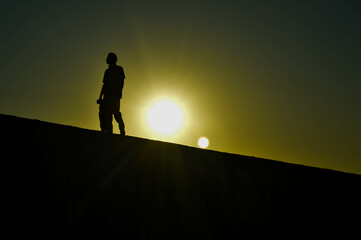 Silhouette of man walking at sunset