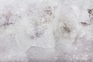 Photo of frozen cracked snow and ice surface texture background.