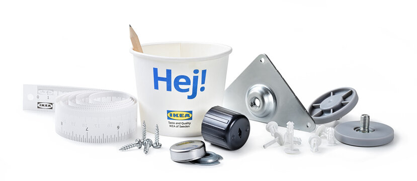 Ikea, pencil meter and paper cup with assembly elements for modular furniture. Isolated on white background, close-up.