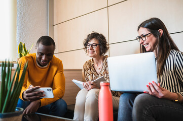 Black man showing something funny on his cell phone to his colleagues.