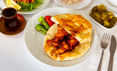 Turkish chicken shish kebab served on pita bread with vegetable garnish. Dish of authentic cuisine