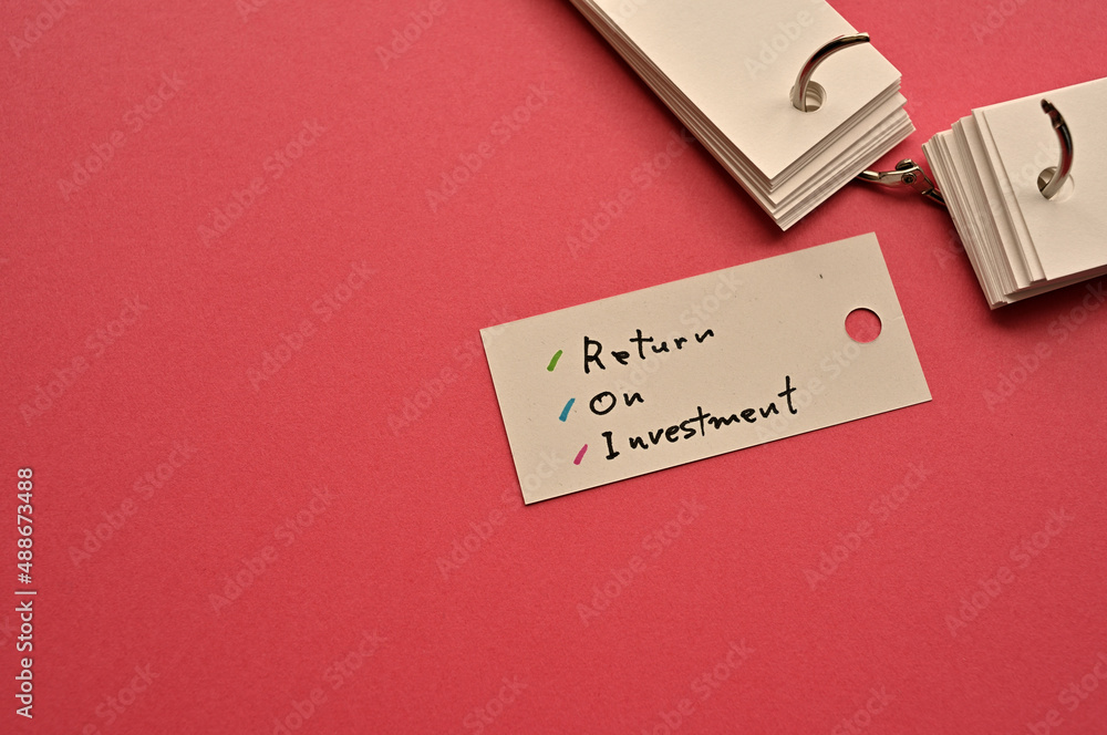 Poster there is a small card placed on a red background paper with the word return on investment written on