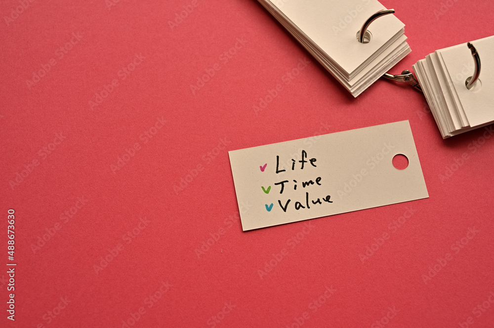 Poster there is a small card placed on a red background paper with the word life time value written on it. 
