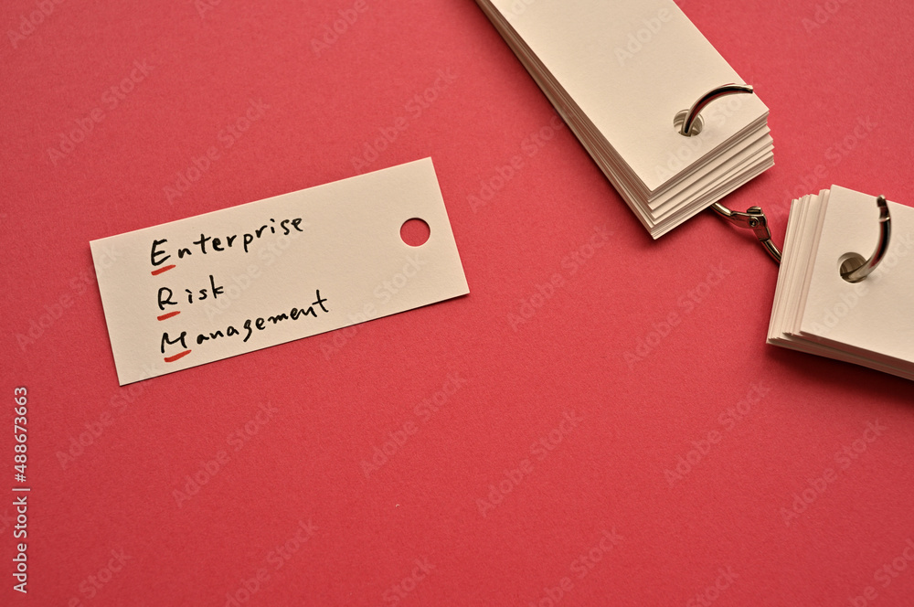 Poster there is a small card placed on a red background paper with the word enterprise risk management writ