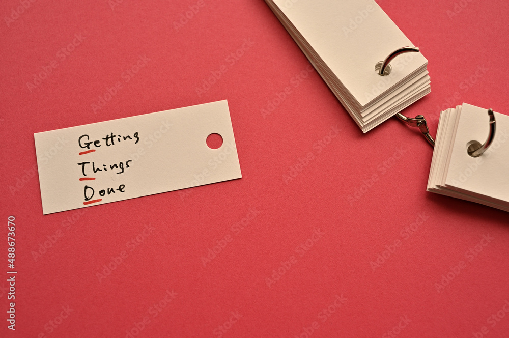 Poster there is a small card placed on a red background paper with the word getting things done written on 