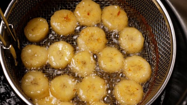 Cooking fried bananas in fryer fat. Closeup