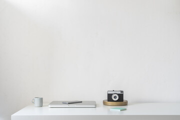 Home office desk with office supplies and white wall copy space.	
