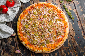 Mexican pizza with meat and jalapeno on old wooden table top view