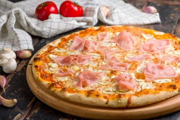Foto op Plexiglas Pizza with ham and mushrooms with steam on old wooden table macro close up © Алиса Королевская