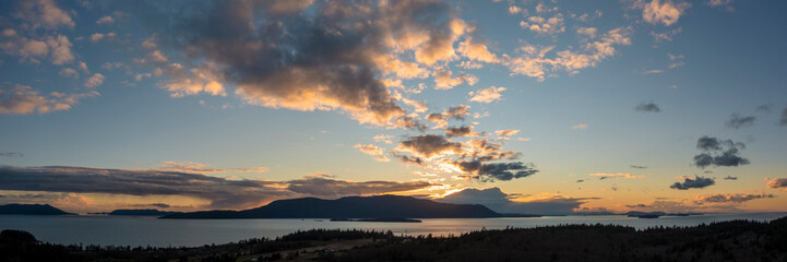 Fototapeta premium Sunset Over Orcas Island, Washington. Located in the San Juan Islands this drone view and dramatic clouds was taken from Lummi Island looking across Rosario Strait in the Salish Sea.