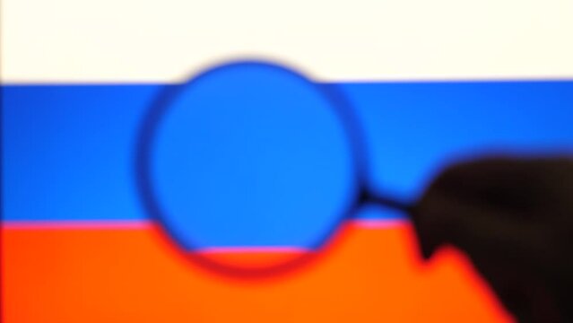 Men's Hand With Magnifier explored with Russian flag