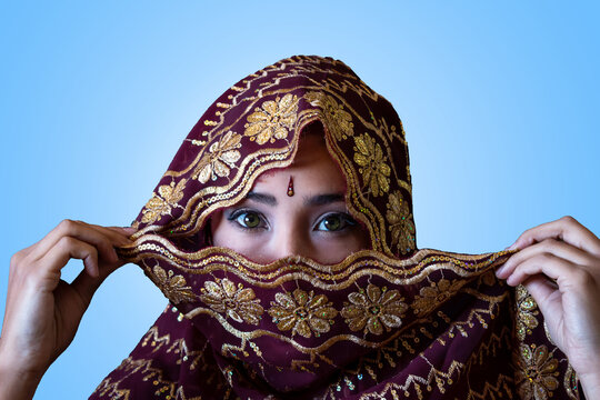 Mujer hindú mirando la cámara y tapandose el rostro 