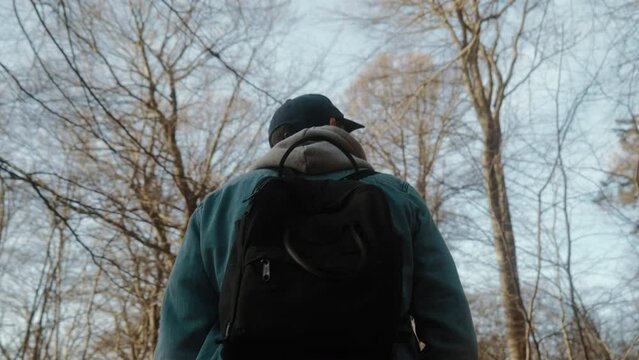 man walking in the forest with backpack on