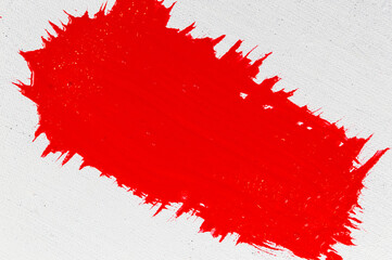 thick red acrylic paint applied in an uneven patch on a flat surface