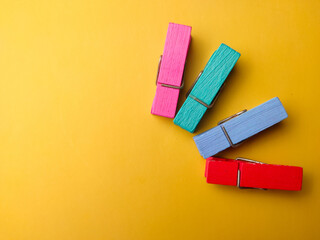 Top view wooden clips with copy space on a yellow background.