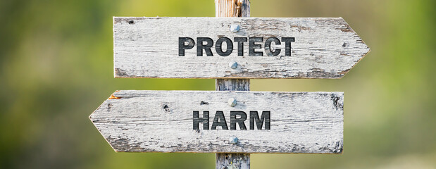 opposite signs on wooden signpost with the text quote protect harm engraved. Web banner format.