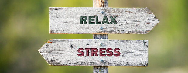 opposite signs on wooden signpost with the text quote relax stress engraved. Web banner format.