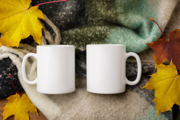 Two white coffee mug mockup with woolen scarf and fall leaves