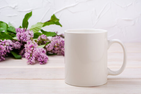 White coffee mug mockup with lilac near painted wall