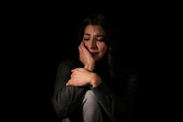Latin young woman suffering depression on isolated black background