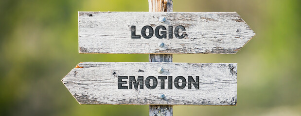 opposite signs on wooden signpost with the text quote logic emotion engraved. Web banner format.