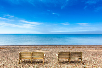 Bancs contemplant la mer sur une plage de gallets aux Iles-de-la-Madeleine au Qu&eacute;bec