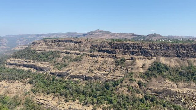 Dry hills of kandala Brown crack surface limestone mountain with green tree leaf, height blue cement pattern hill and dry grass field landscape, white mortar horn texture with forest geology isolated 