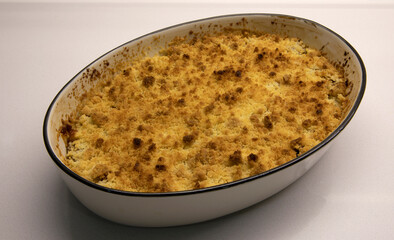 Gastronomy. Sweet desserts. Top view of a crusty apple crumble dish served on a bowl on the table...