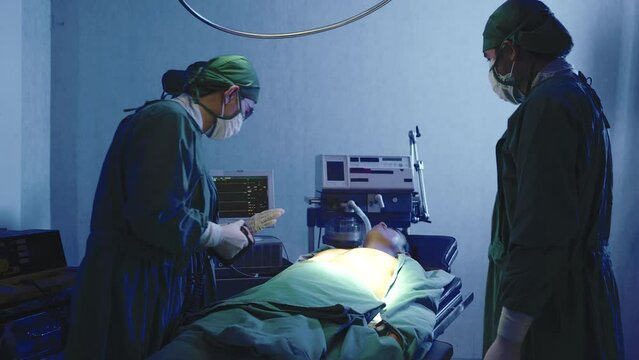 Defibrillation cardiac dysrhythmia, Surgical doctor team performing surgery patient on operating room in hospital, doctors use medical devices automated External Defibrillator to pump hearts patients