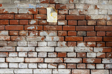 Old brick wall with peeling paint and faded paper ad, advertising backdrop, for 3D textures or materials