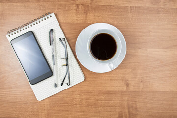 Coffee at work or office, top view, cup of coffee and stationery on desktop, top view, space for text, copy space.