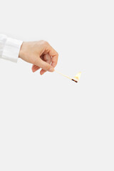 Woman hand holds lit match. Wooden matchstick is burning. Fire Hazard concept.
