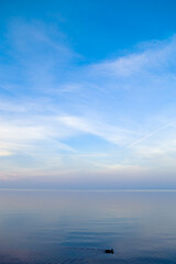 Sky background on sunset, colorful clouds. Nature abstract composition with reflections on sea water. Nature environment.