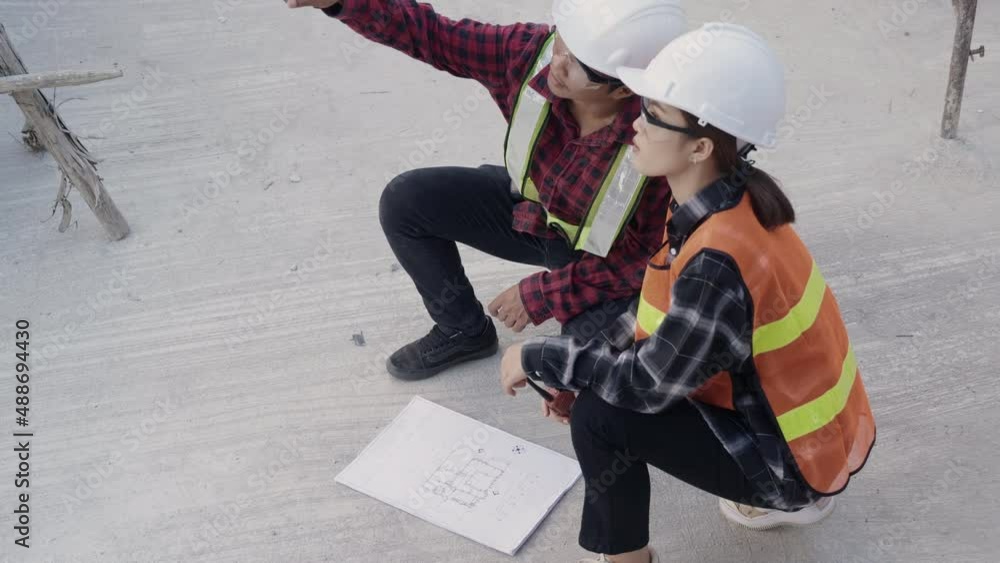 Poster architect and client discuss help create plan with blueprint of the building at construction site fl
